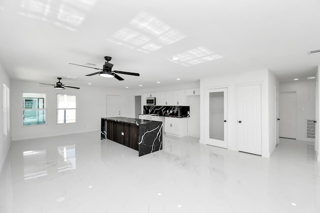 kitchen featuring white cabinets, ceiling fan, and a kitchen island