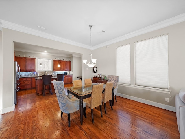 dining area with crown molding and dark wood-type flooring