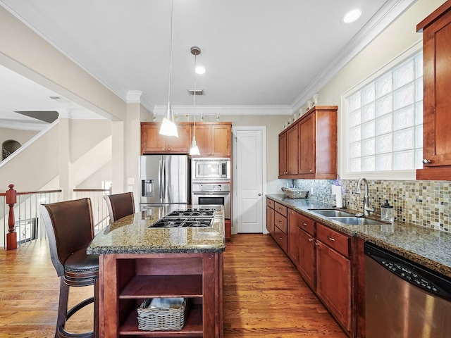 kitchen featuring stainless steel appliances, a kitchen island, hardwood / wood-style flooring, and sink