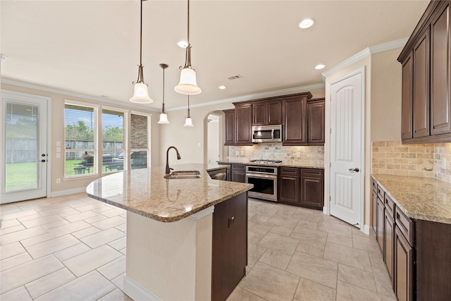 kitchen with sink, hanging light fixtures, stainless steel appliances, tasteful backsplash, and light stone counters