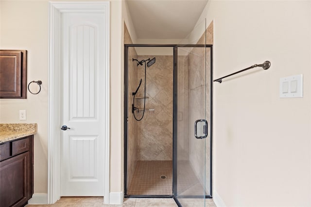 bathroom with tile patterned floors, vanity, and a shower with shower door