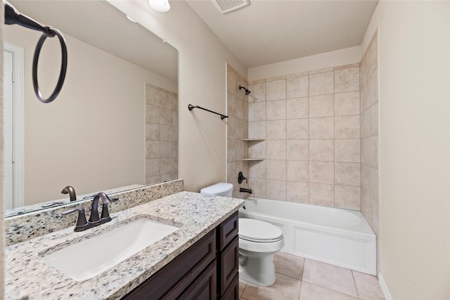 full bathroom with tile patterned flooring, vanity, tiled shower / bath combo, and toilet