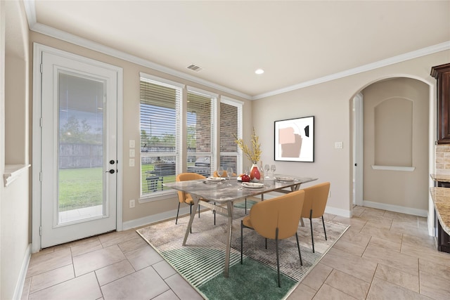 tiled dining space featuring crown molding