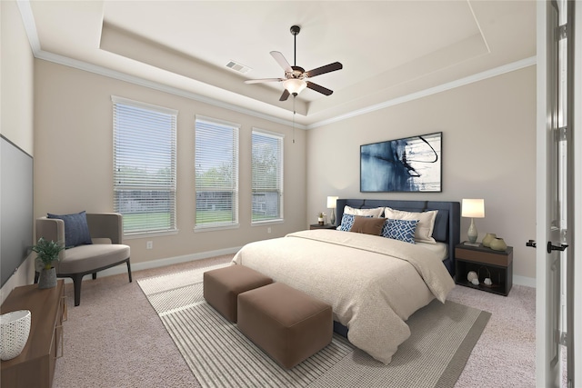 bedroom with ceiling fan, a raised ceiling, light colored carpet, and crown molding