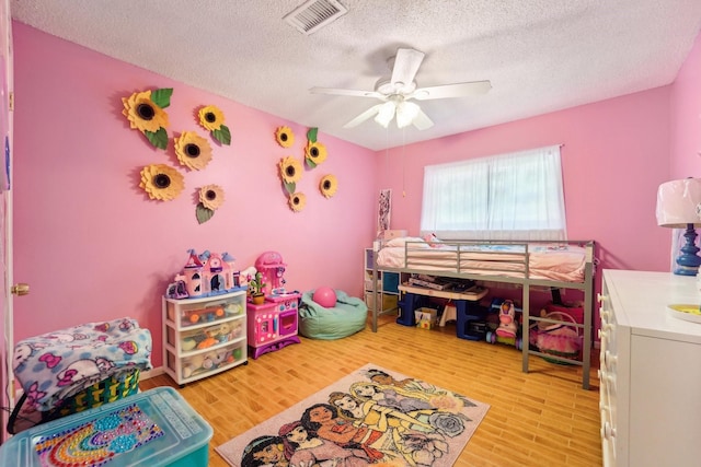 bedroom featuring ceiling fan, a textured ceiling, and hardwood / wood-style flooring