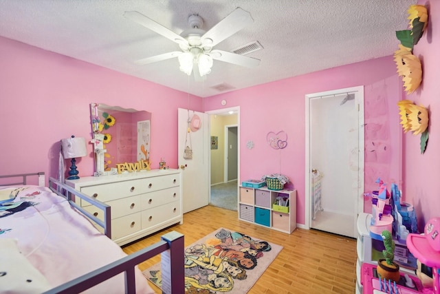 bedroom with ceiling fan, a textured ceiling, and light wood-type flooring