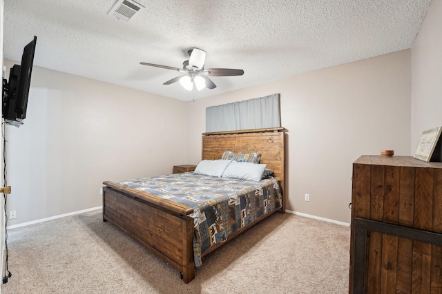 carpeted bedroom with ceiling fan and a textured ceiling