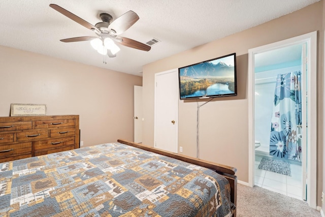 carpeted bedroom featuring a textured ceiling, connected bathroom, a closet, and ceiling fan