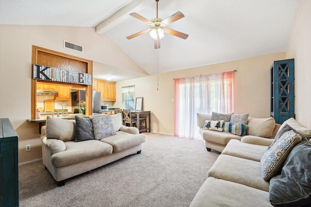 living room with vaulted ceiling with beams, ceiling fan, sink, and carpet