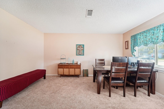 carpeted dining space featuring a textured ceiling