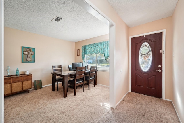 carpeted entryway with a textured ceiling