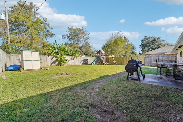 view of yard featuring a playground and a storage shed