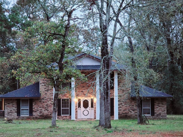 view of front of house with cooling unit and a front yard