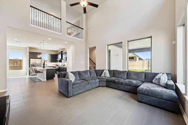 living room with a high ceiling, ceiling fan, and sink