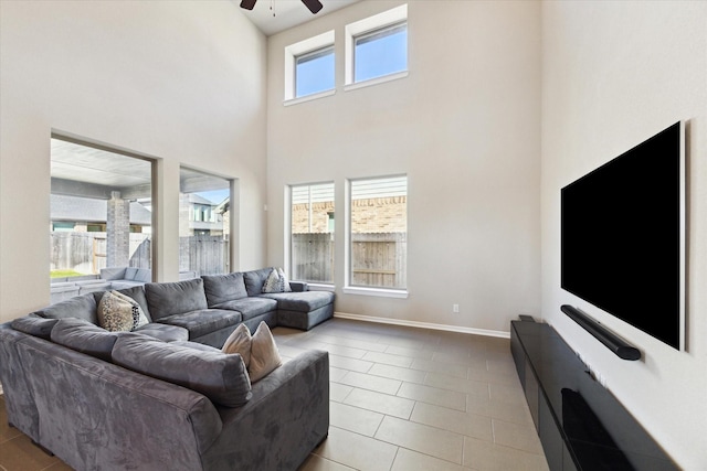 living room featuring light tile patterned floors, a towering ceiling, and ceiling fan