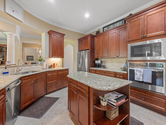 kitchen featuring backsplash, crown molding, sink, stainless steel appliances, and decorative columns