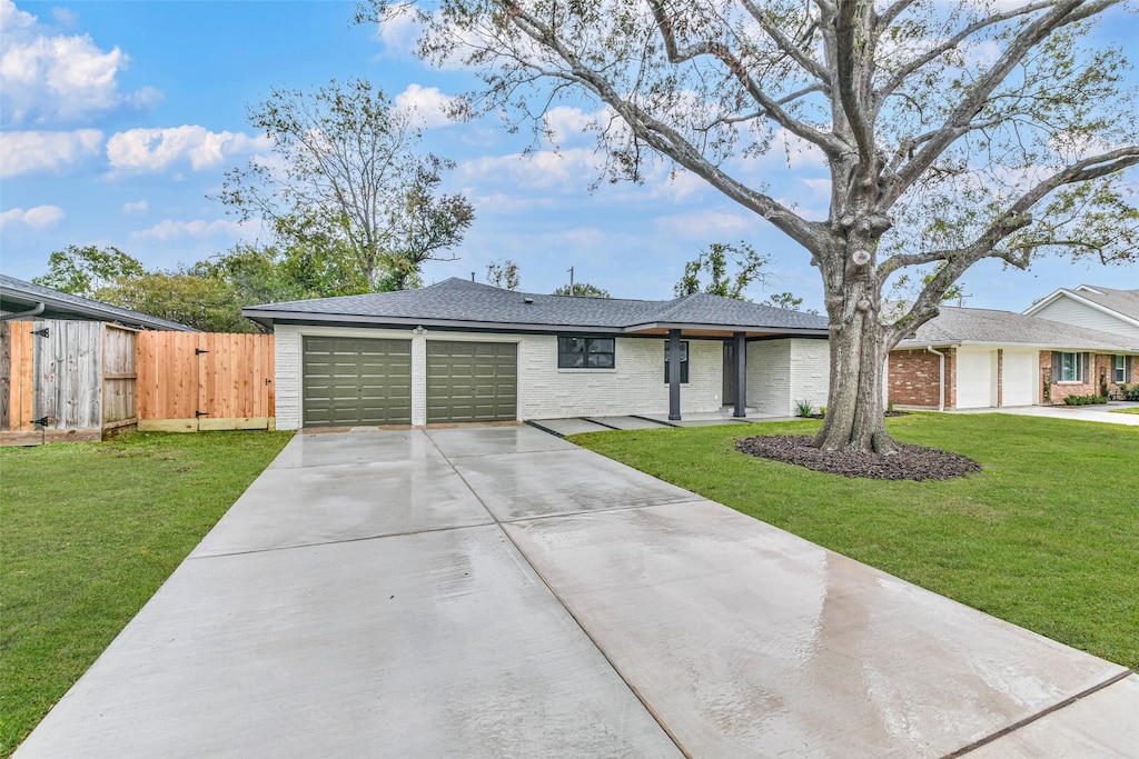 single story home with a garage and a front lawn