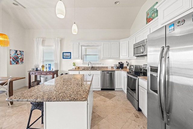 kitchen featuring a center island, lofted ceiling, white cabinets, sink, and stainless steel appliances