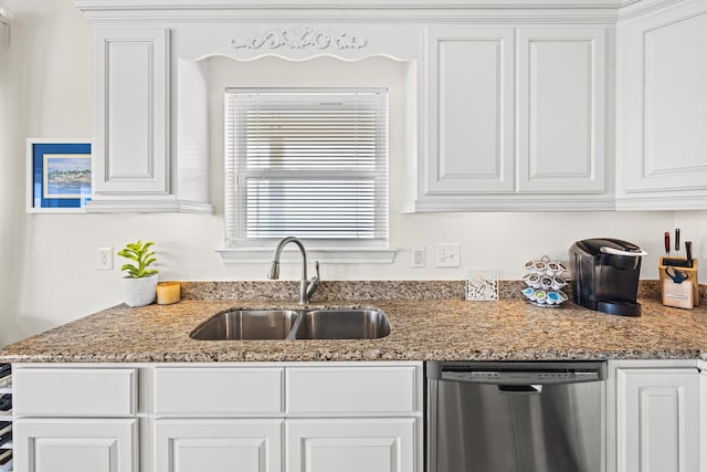 kitchen featuring stainless steel dishwasher, light stone counters, white cabinets, and sink