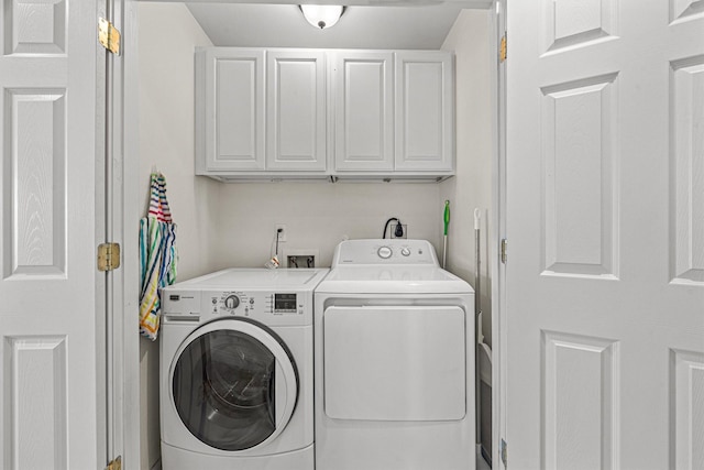 laundry room with cabinets and washing machine and clothes dryer