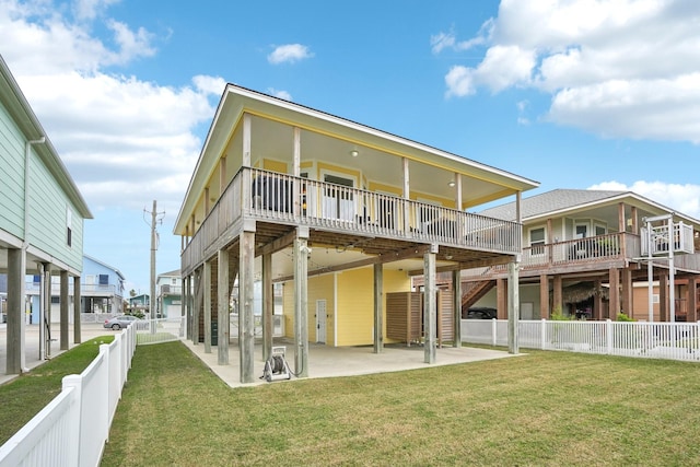 back of house with a wooden deck, a yard, and a patio