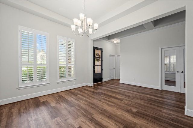 empty room with a notable chandelier, dark hardwood / wood-style flooring, and crown molding