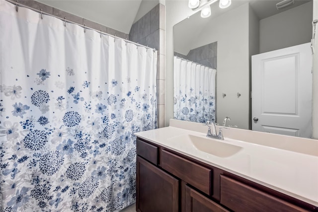 bathroom with vanity, vaulted ceiling, and curtained shower