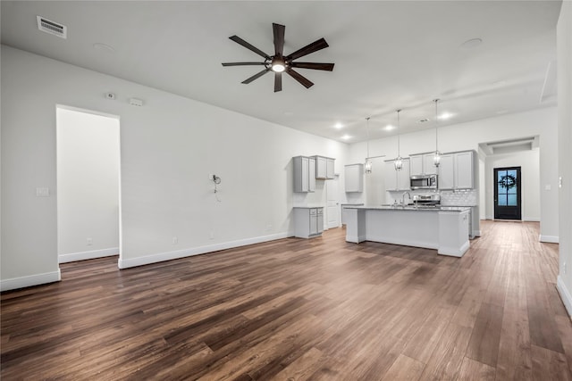 unfurnished living room with wood-type flooring and ceiling fan