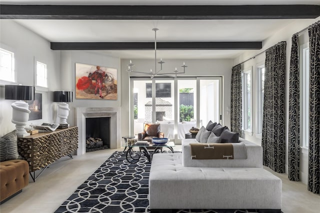 living room with a fireplace, beam ceiling, a chandelier, and plenty of natural light