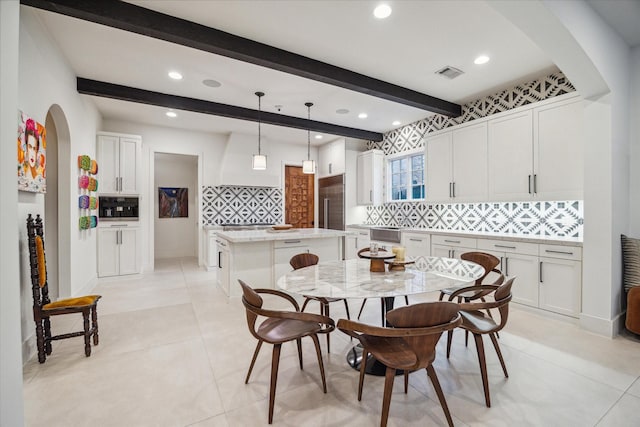 dining room with beam ceiling and light tile patterned flooring