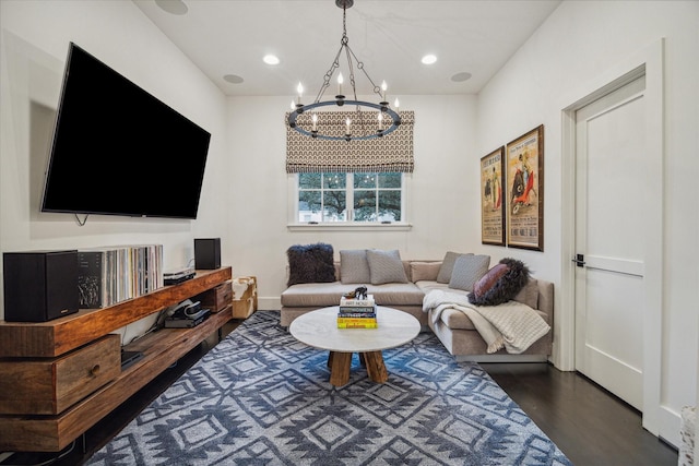 living room with dark hardwood / wood-style floors and an inviting chandelier