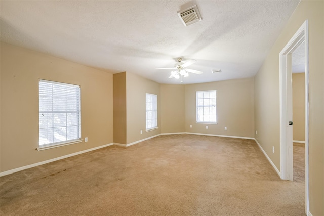 empty room featuring light carpet, a textured ceiling, and ceiling fan