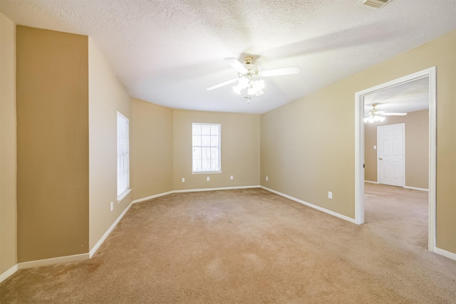 carpeted empty room featuring a textured ceiling and ceiling fan