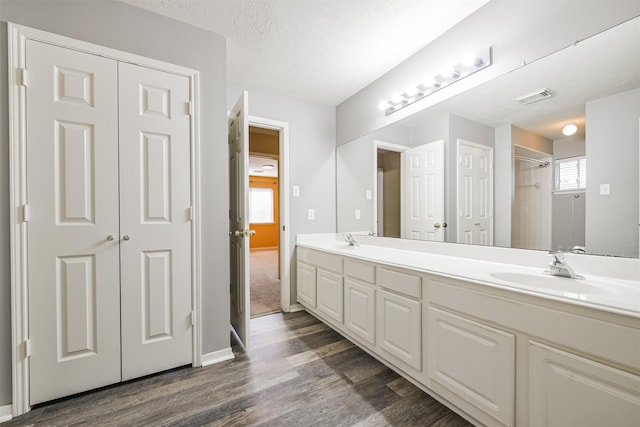 bathroom featuring hardwood / wood-style floors, vanity, and a textured ceiling