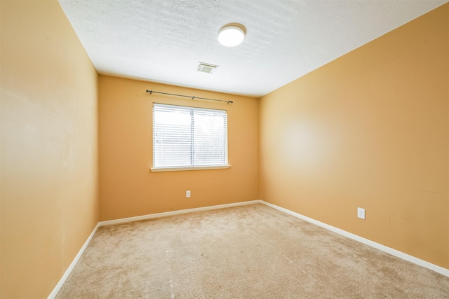 carpeted spare room featuring a textured ceiling