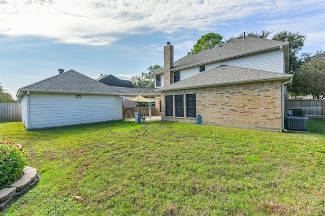 back of property featuring a yard and central AC unit