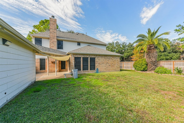 rear view of property featuring a yard and a patio