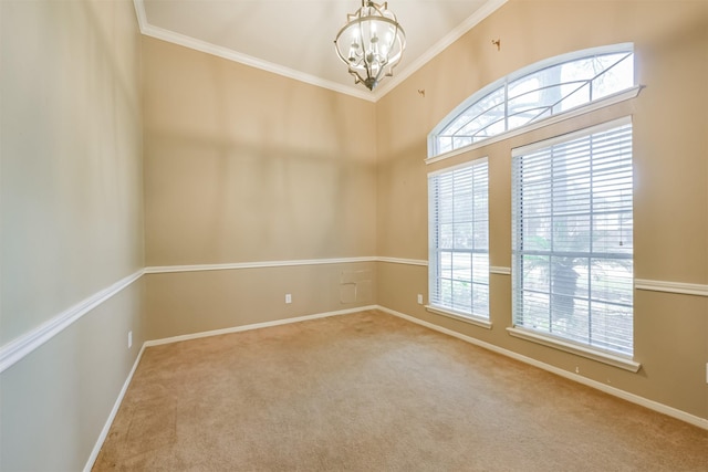 carpeted spare room featuring a wealth of natural light, crown molding, and an inviting chandelier