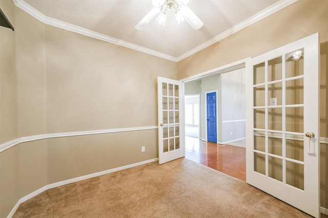 empty room with carpet, ceiling fan, ornamental molding, and french doors