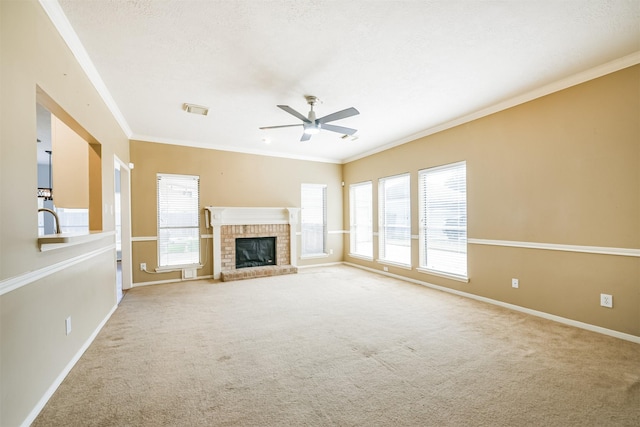 unfurnished living room featuring carpet flooring, ceiling fan, crown molding, and a fireplace