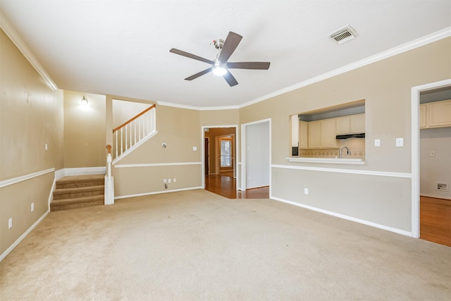 unfurnished living room featuring ceiling fan, crown molding, and light colored carpet