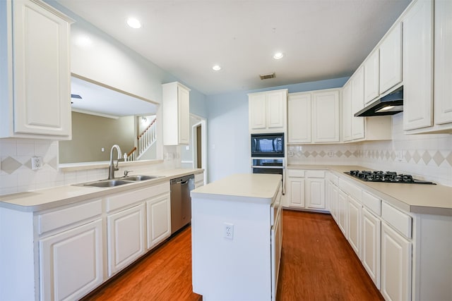 kitchen featuring decorative backsplash, a center island, white cabinetry, and appliances with stainless steel finishes