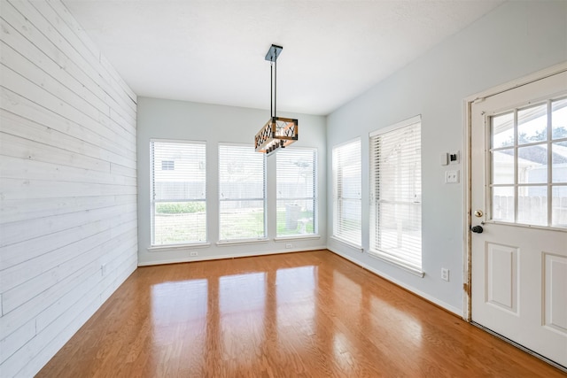 unfurnished dining area featuring light hardwood / wood-style floors and a notable chandelier