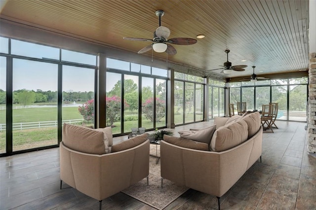 sunroom / solarium featuring ceiling fan, a wealth of natural light, and wood ceiling