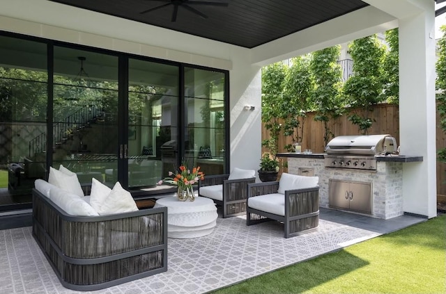 view of patio with area for grilling, ceiling fan, and exterior kitchen