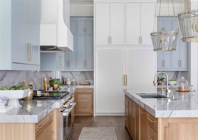 kitchen with light brown cabinets, sink, a kitchen island with sink, high end stainless steel range, and custom range hood