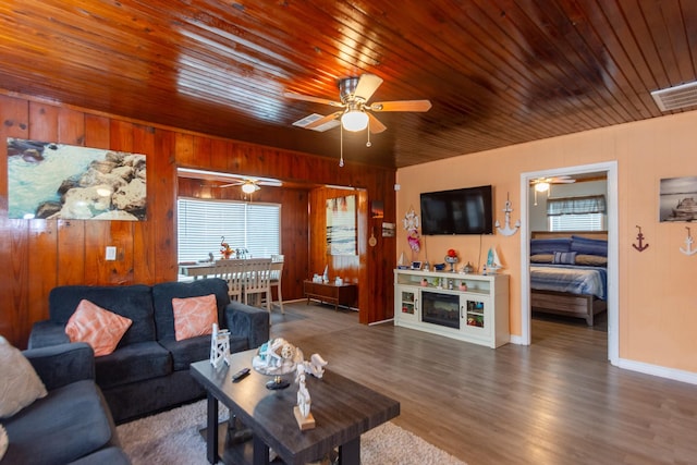 living room with wooden walls, dark hardwood / wood-style flooring, and wood ceiling