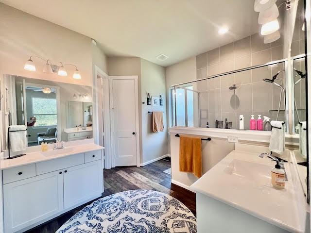 bathroom featuring wood-type flooring, vanity, and walk in shower