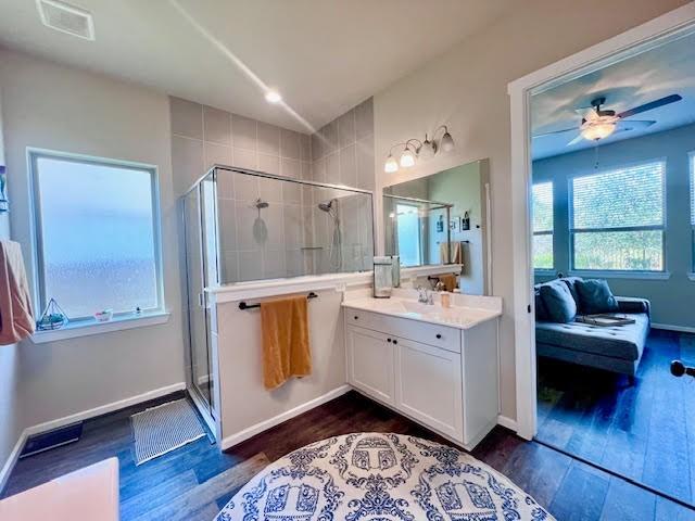 bathroom featuring wood-type flooring, vanity, ceiling fan, and a shower with shower door