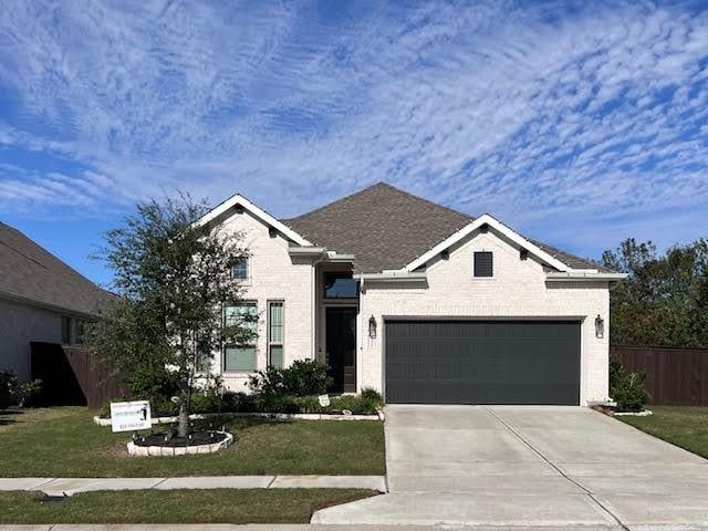 view of front of home featuring a front yard and a garage